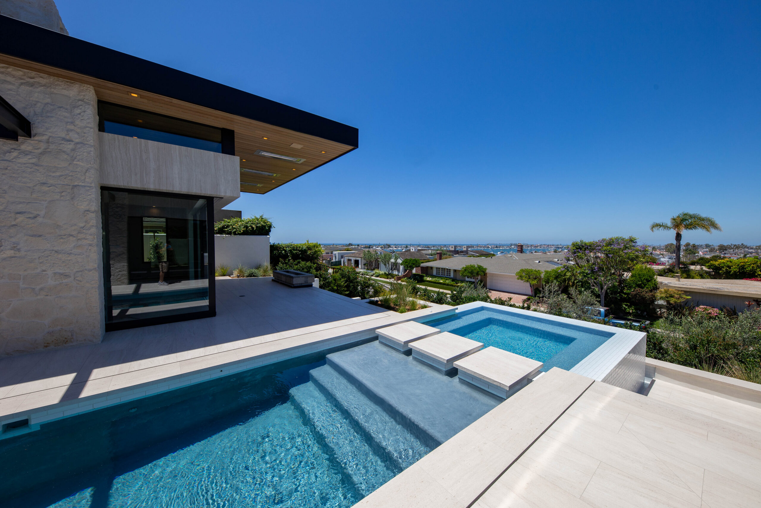 Luxury outdoor stone pool deck installation by Epic Ceramic and Stone in Orange County California