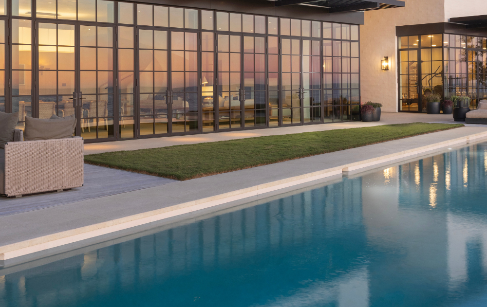 Large-format porcelain pool coping paired with a natural travertine deck surface in a Southern California outdoor living space.
