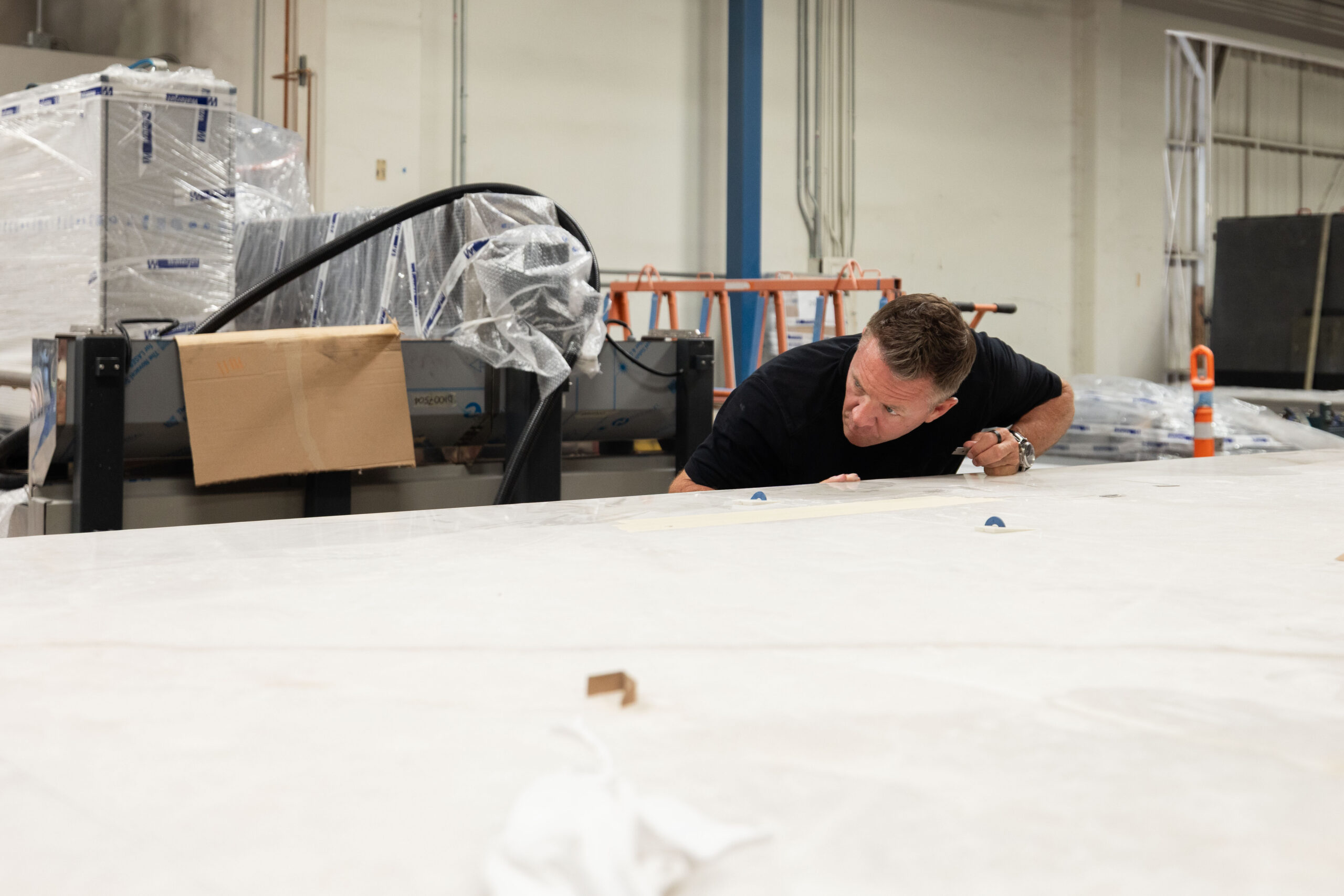 Epic Ceramic & Stone team member inspecting a natural stone slab during the fabrication quality control process